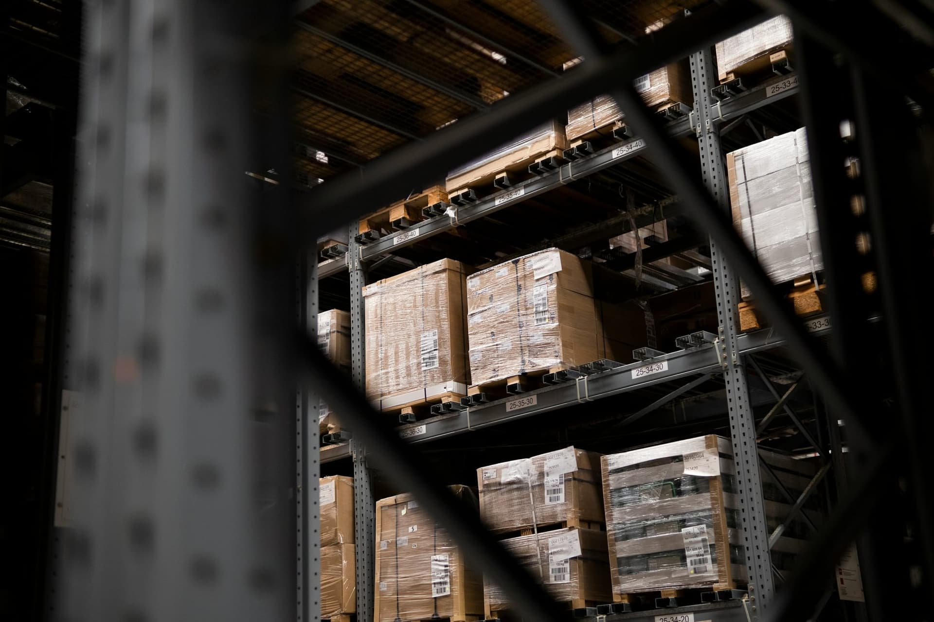 Shrink-wrapped pallets stored on warehouse racking with location labels