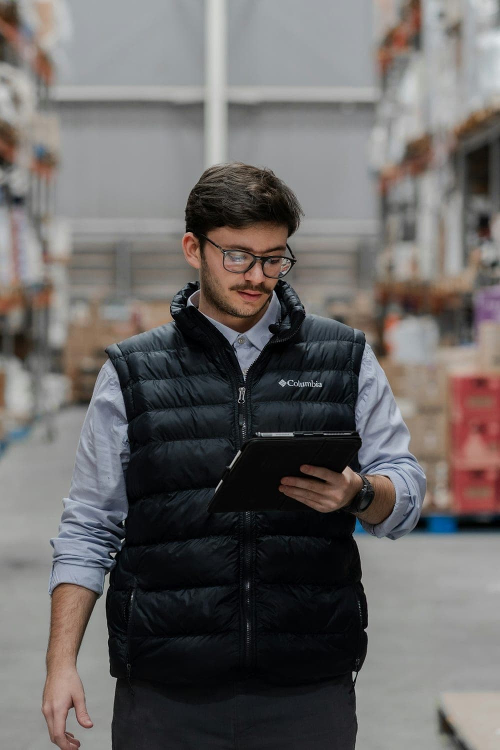 Warehouse worker checking shipment paperwork against stock