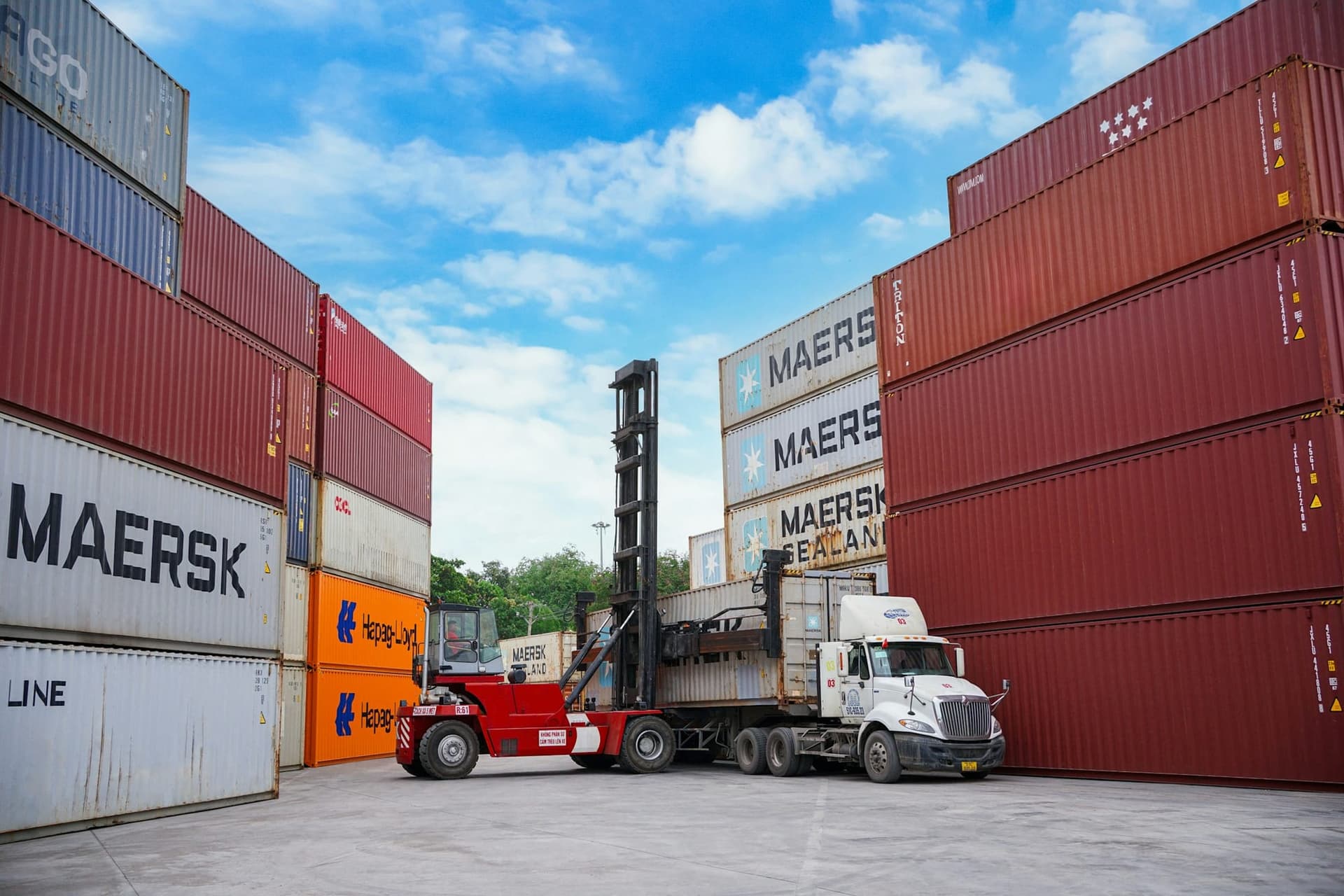 Container handler moving shipping containers in a port yard