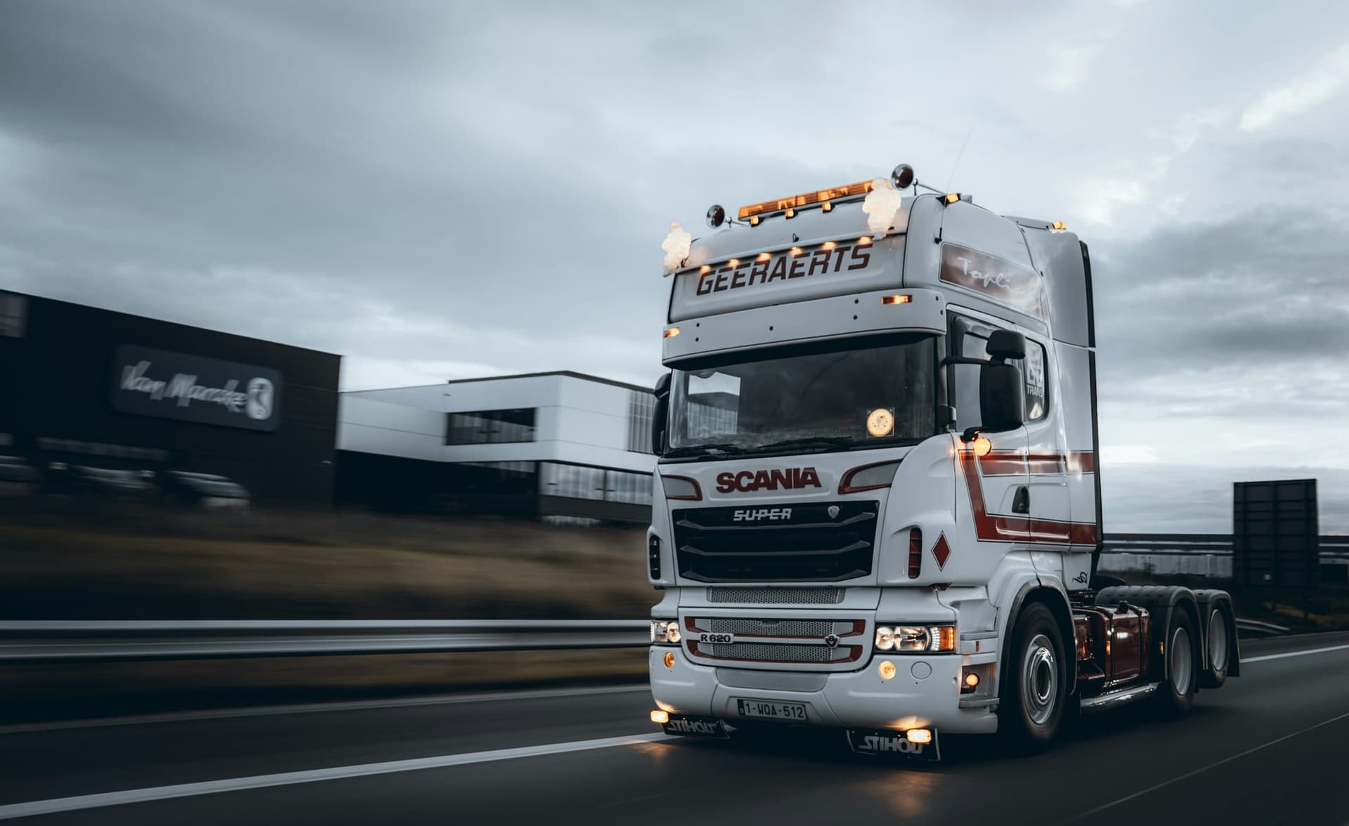 Articulated lorry on a European road beside a distribution building