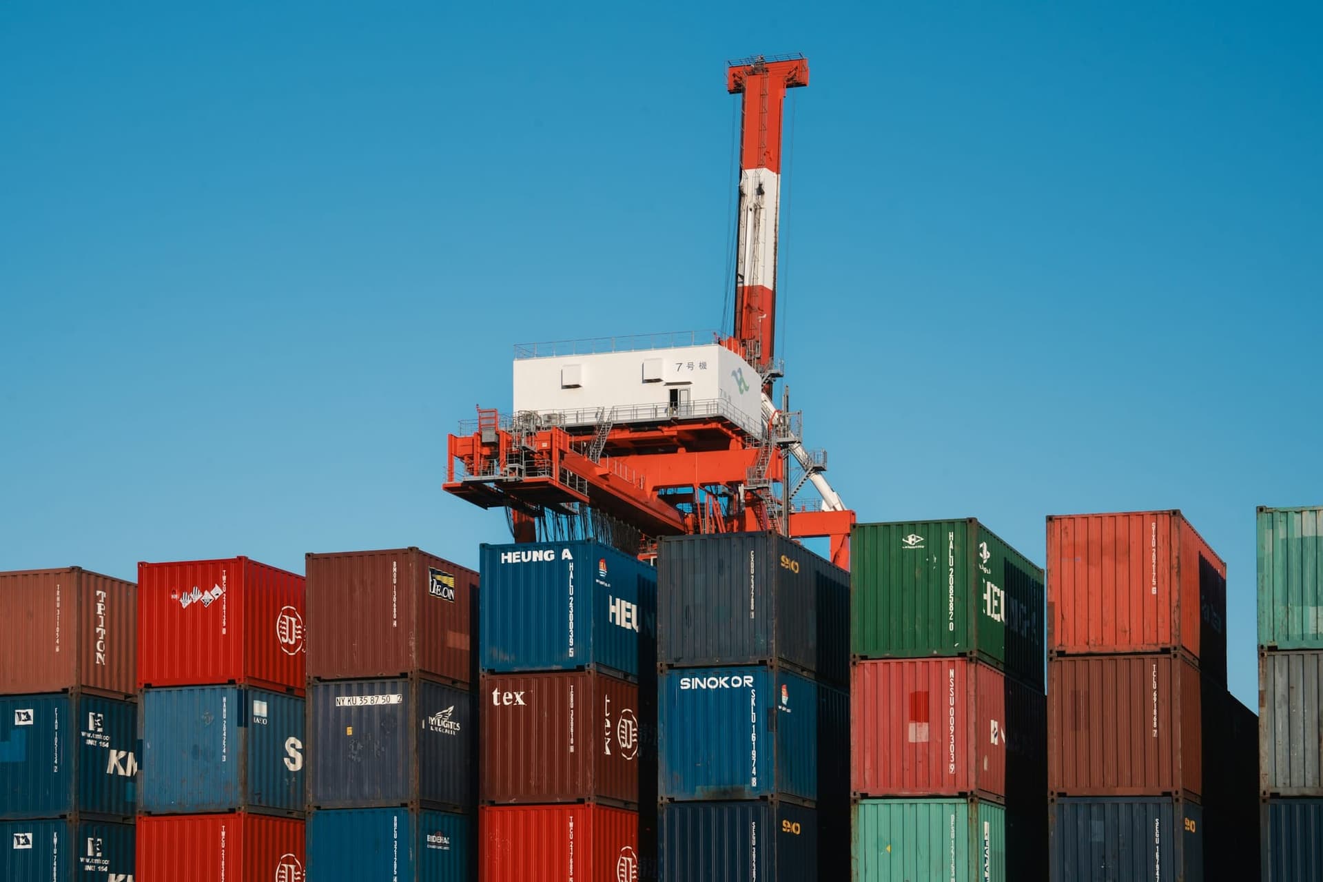 Container stacking crane above rows of shipping containers