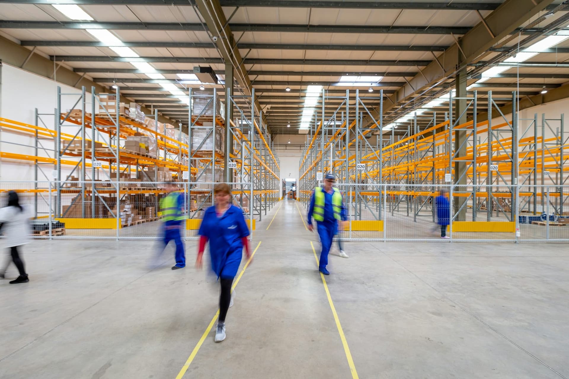 Warehouse staff moving through an aisle in a distribution centre